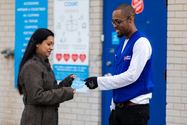 Salvation Army worker distributes voucher to thrift store guest